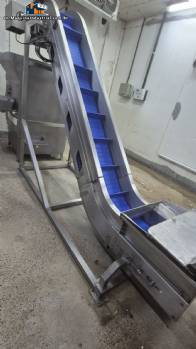 Inova Industrial inclined stainless steel conveyor belt with cleats.